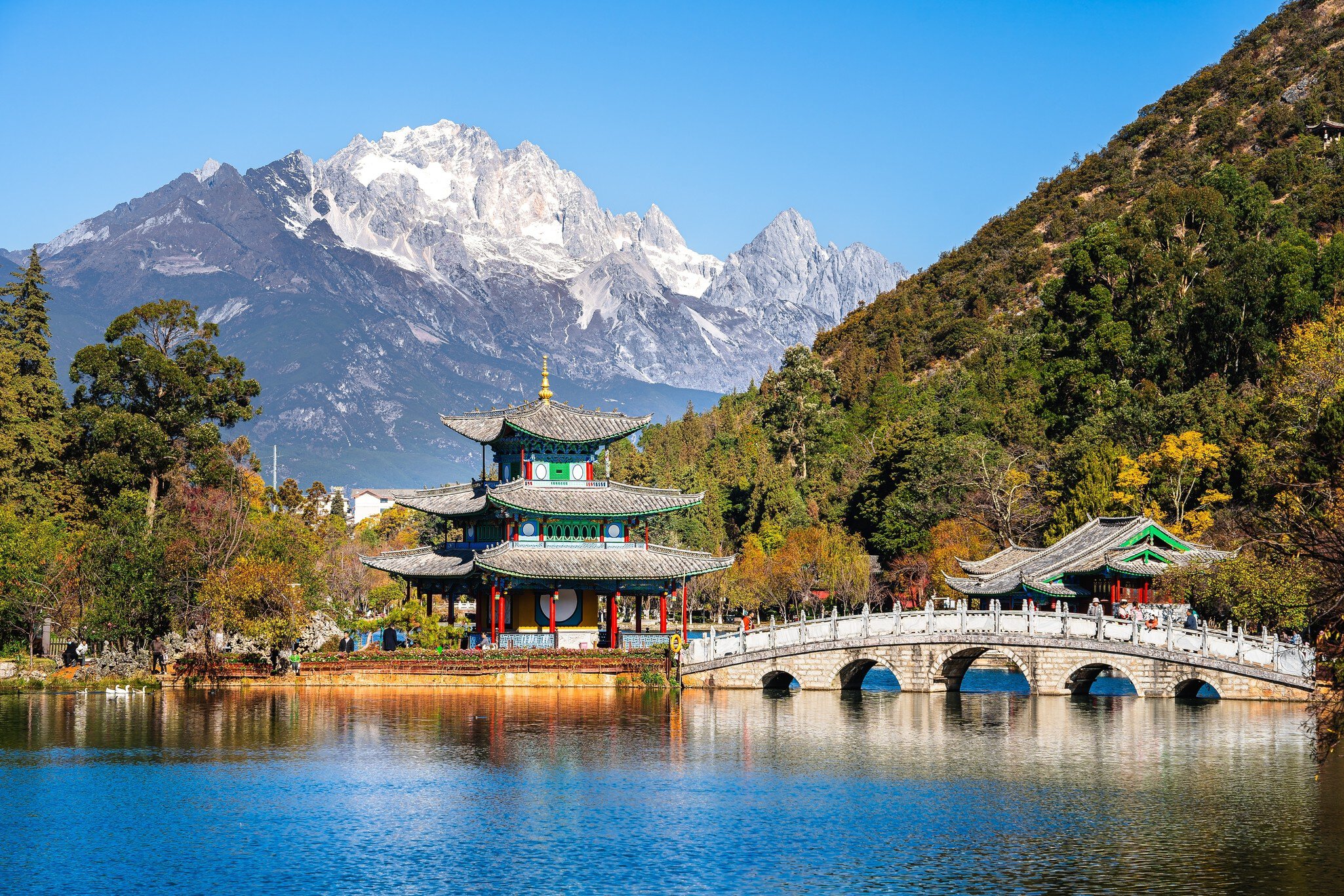 Pagoda and arched marble bridge on Black Dragon Pool in Lijiang with snowy Jade Dragon Snow Mountain behind