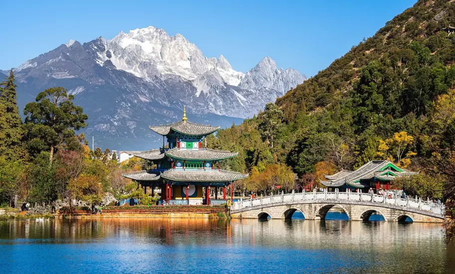 Pagoda and arched marble bridge on Black Dragon Pool in Lijiang with snowy Jade Dragon Snow Mountain behind