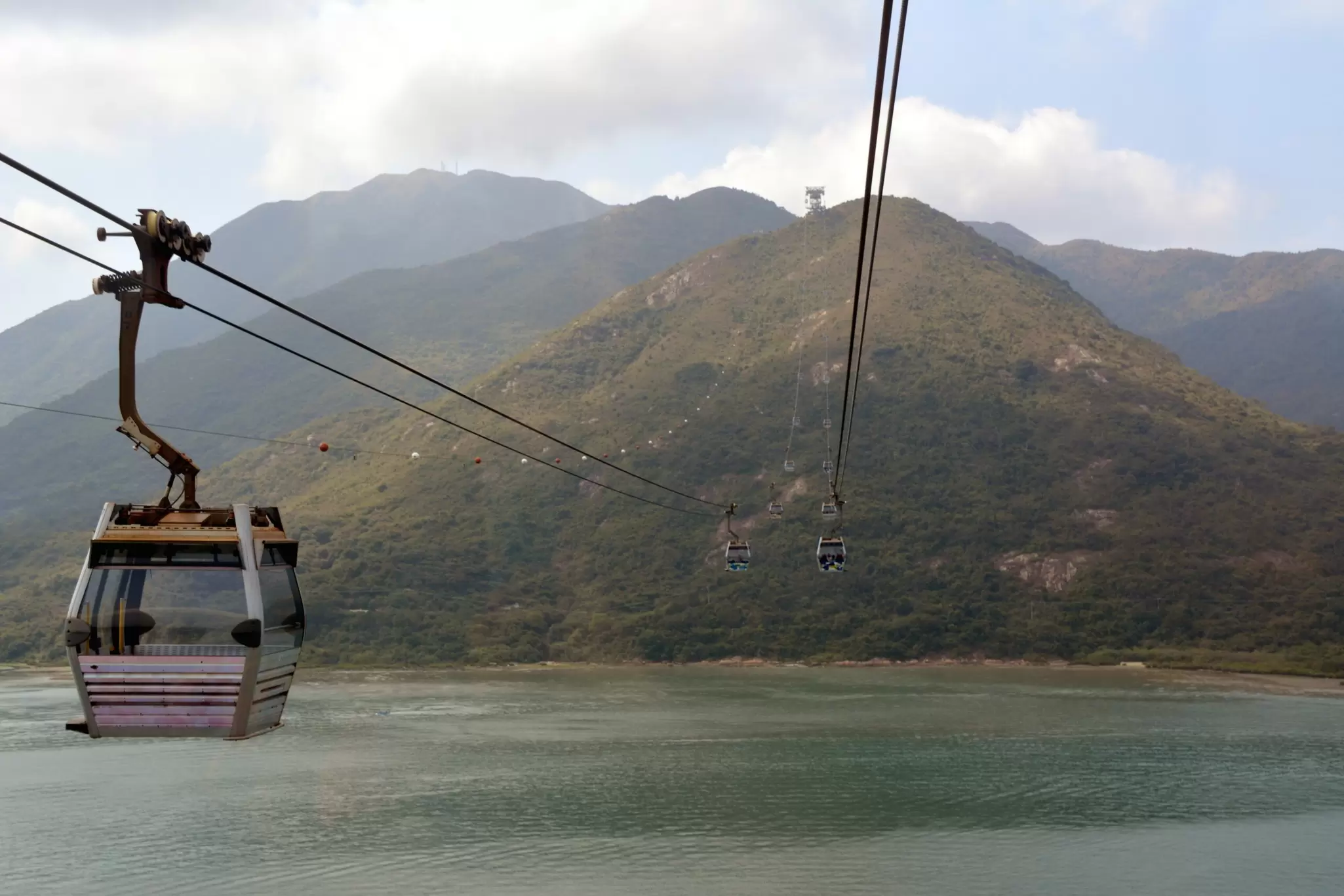 View of the Ngong Ping 360 cable car passing over water on the way to Lantau Island in Hong Kong.
