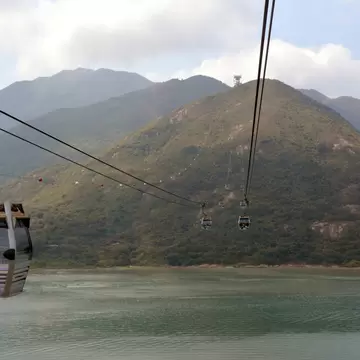 View of the Ngong Ping 360 cable car passing over water on the way to Lantau Island in Hong Kong.
