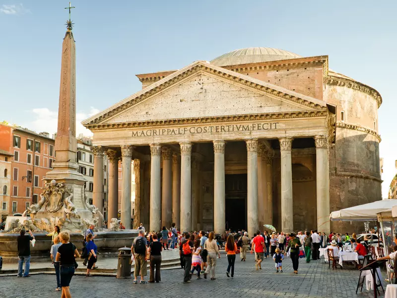 People walk through a square in Rome with the Pantheon in the background