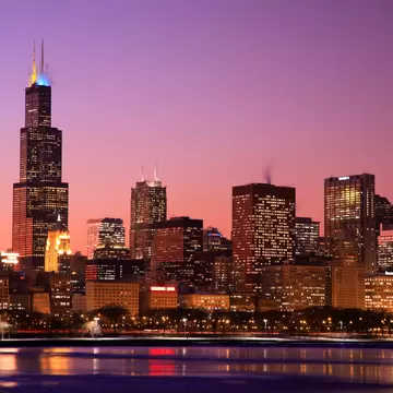 Chicago skyline at dusk, with the Willis Tower rising against a colorful sky.