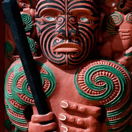 A carved statue of a human figure painted red and green.