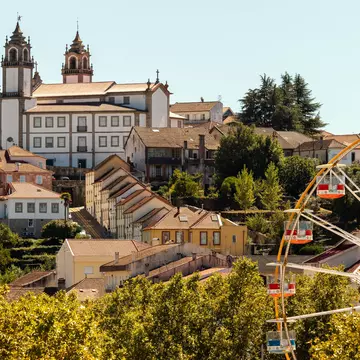 Viseu Cathedral in the background with the Ferris wheel at the São Mateus fair in the foreground