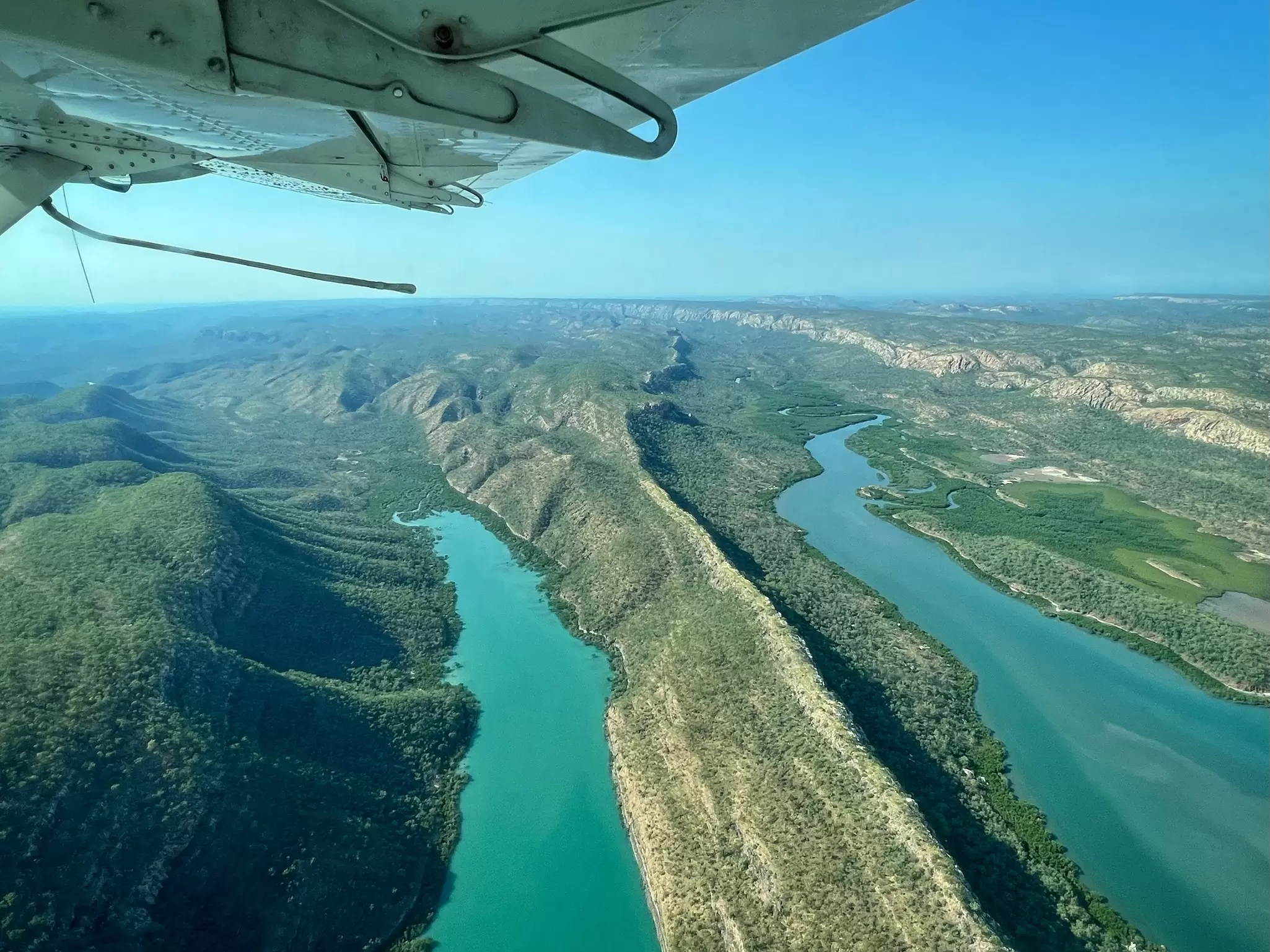 Two parallel gorges filled with water as seen out the window of a sea plane.