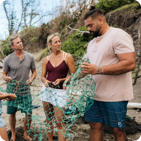 Three people holding plastic.