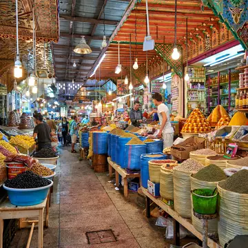 A walkway through stalls selling food and spices at a souq in Morocco.