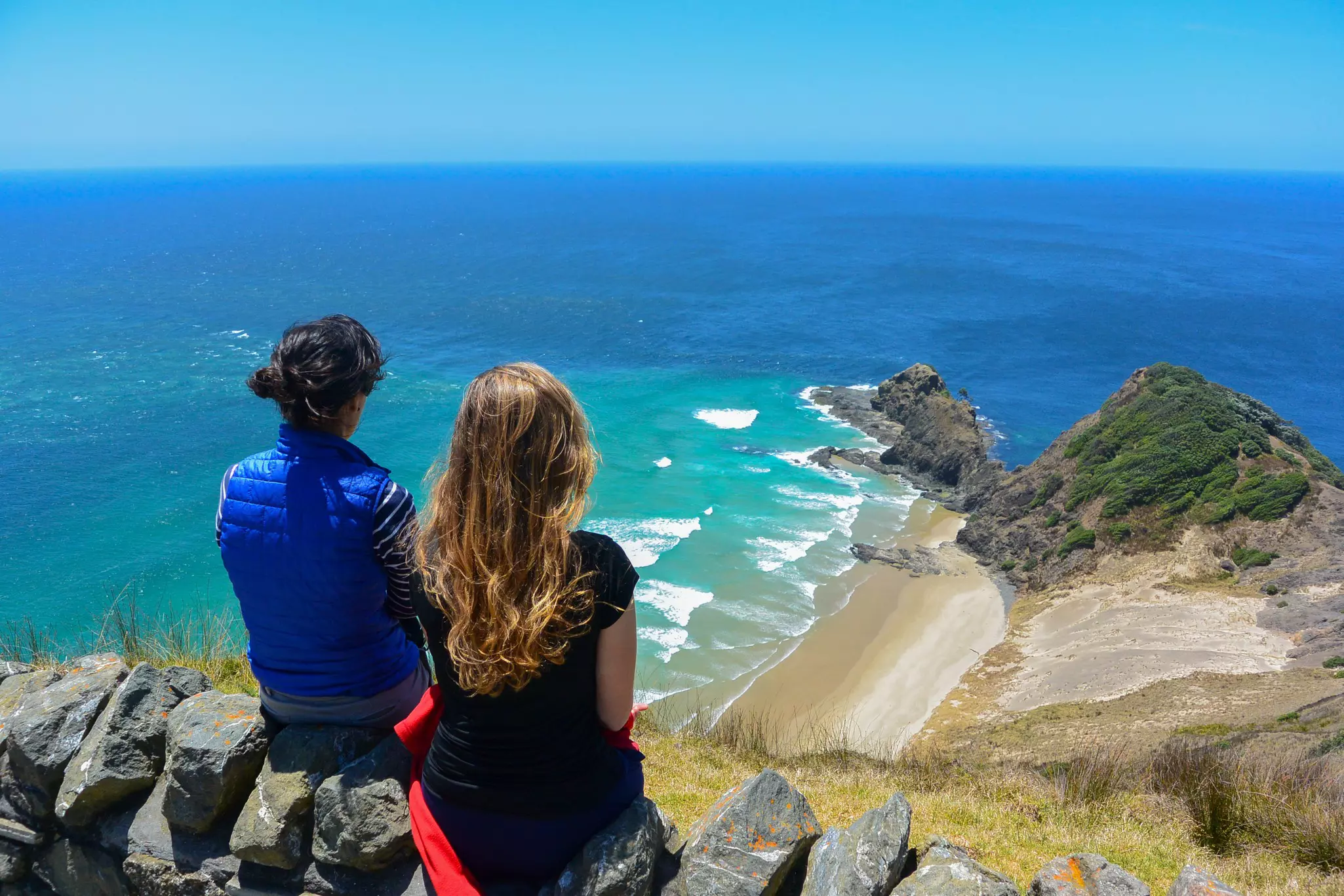 Two women looking at the view from Cape Reinga, north edge of New Zealand.