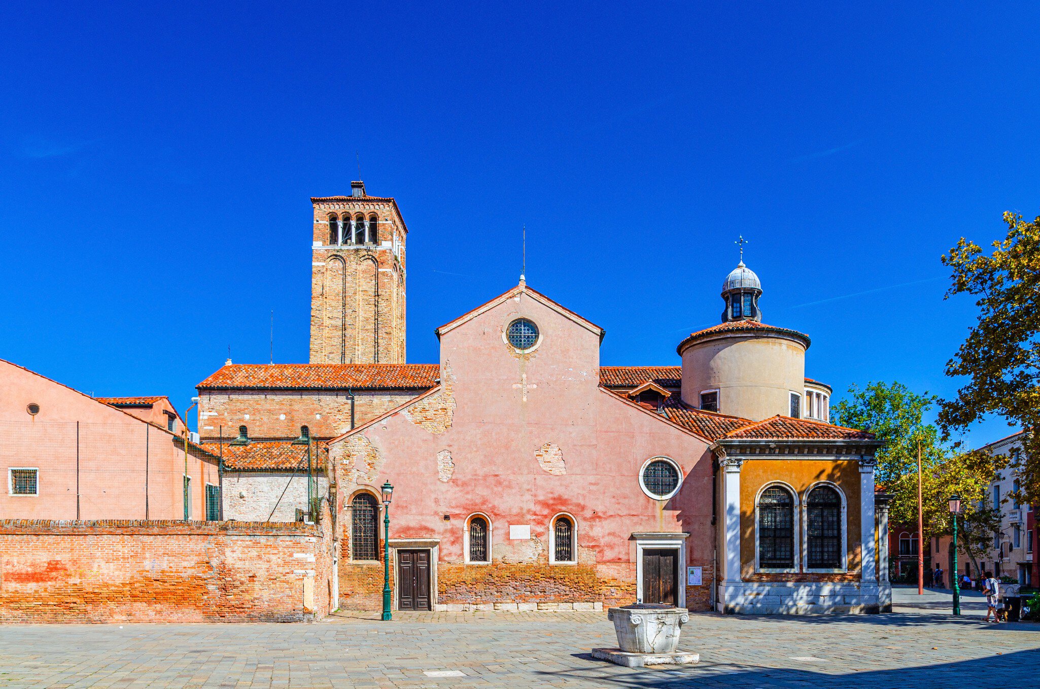 Chiesa di San Giacomo dall'Orio or San Giacomo Apostolo catholic church building with bell tower in Venice historical city centre, blue clear sky background in summer day, Veneto Region, Italy