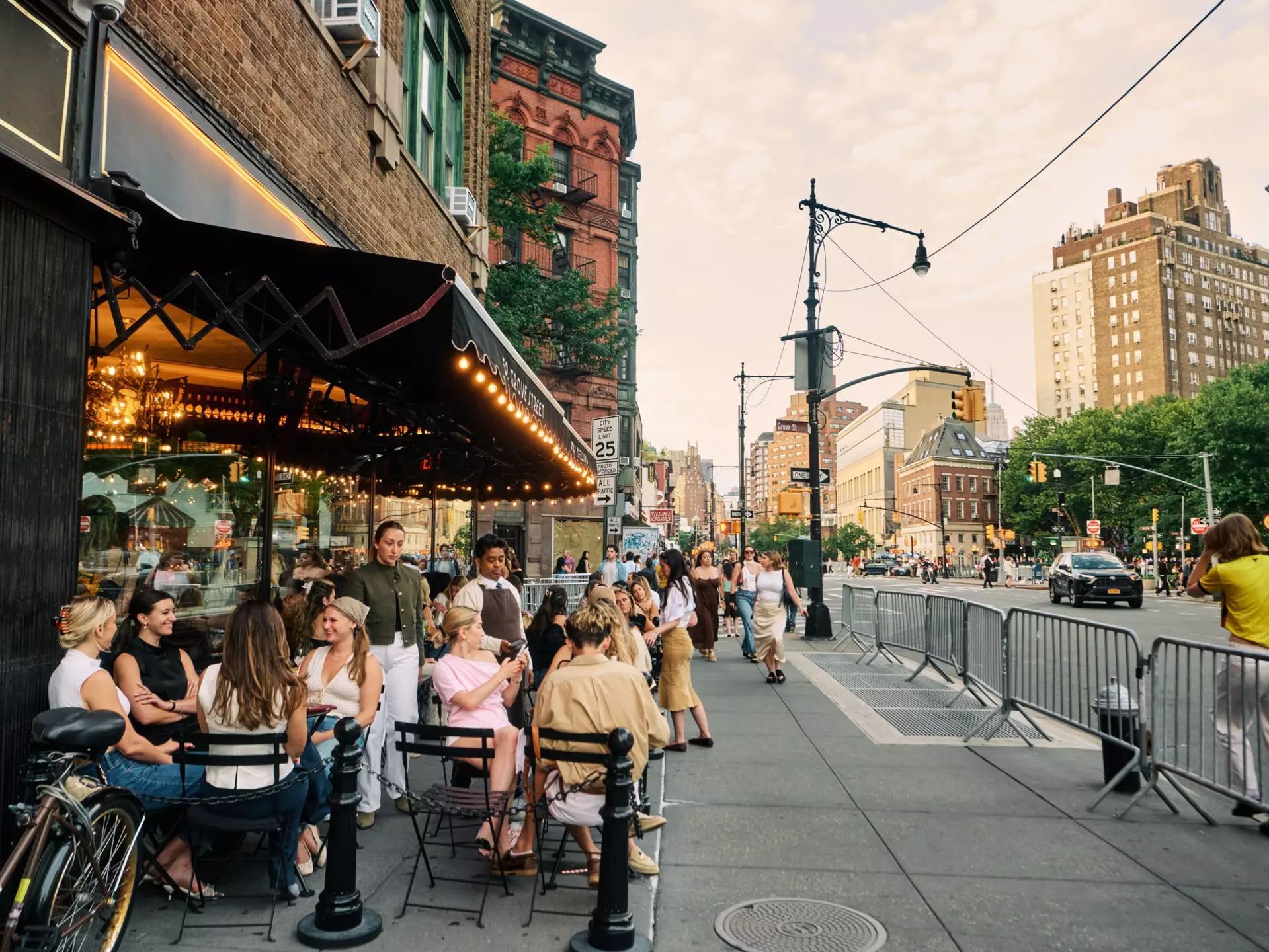 People sitting and chatting in outdoor dining on a New York City street.