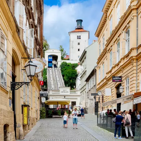 Historic Tomićeva St with cream-colored buildings and the Zagreb Funicular railway.