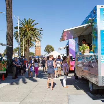 Sunday market stalls along the esplanade in St Kilda located on the foreshore of Port Phillip Bay. Temporary concession stands sell hot and cold take away foods.