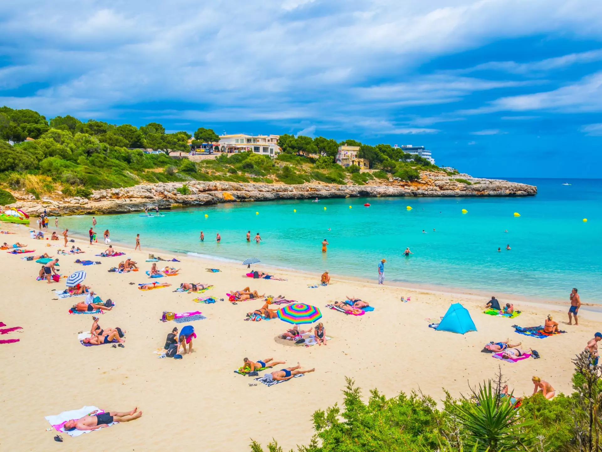 People sun bathing and swimming at Cala Marcal beach