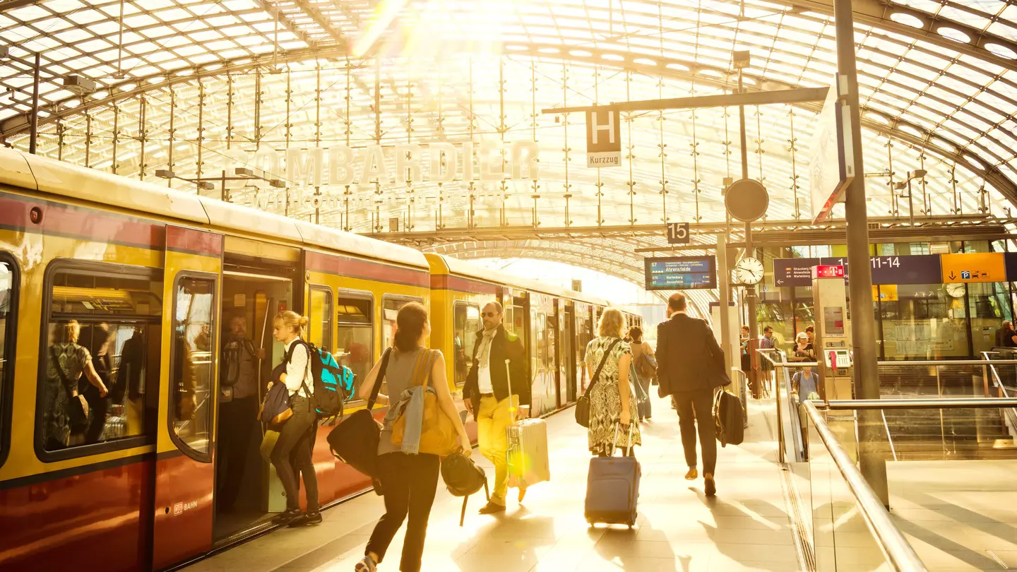Passengers moving through modern main railway station at Berlin Hauptbahnhof as the S-Bahn train waits for passengers to board © Nikada / Getty Images