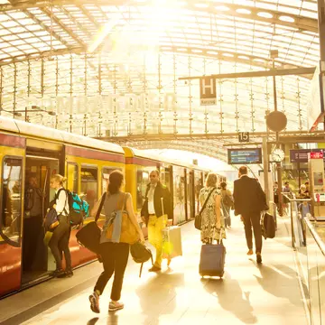 Passengers moving through modern main railway station at Berlin Hauptbahnhof as the S-Bahn train waits for passengers to board © Nikada / Getty Images