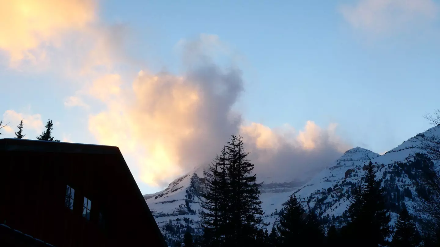 A cloudy sunset over snowy mountains