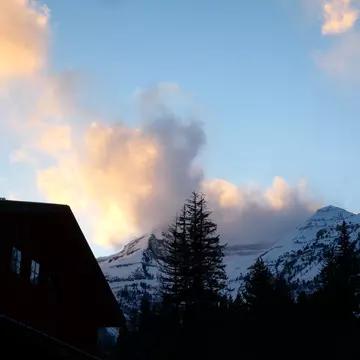 A cloudy sunset over snowy mountains