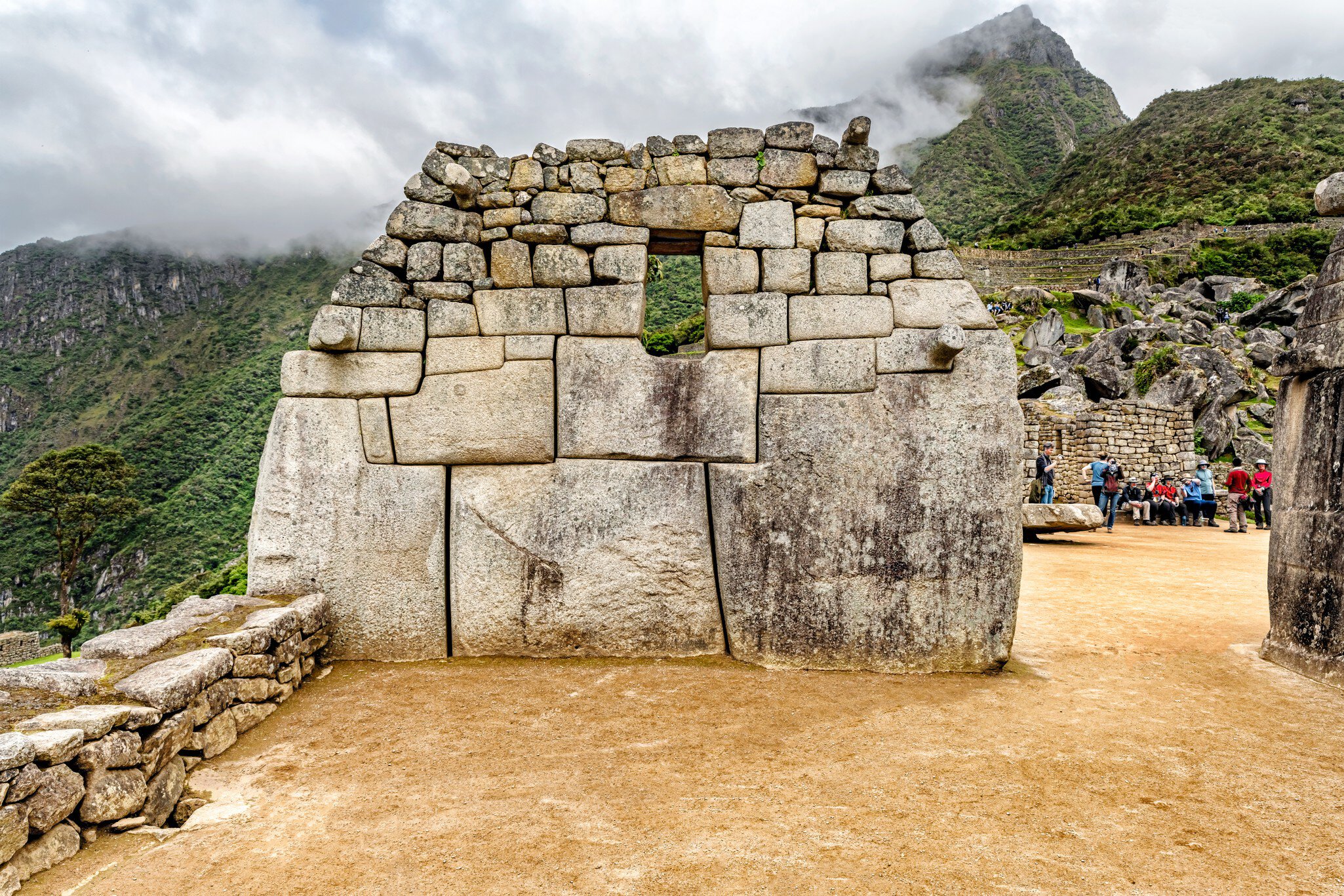 Tourists at Sacred Plaza structures in Machu Picchu, Peru.
