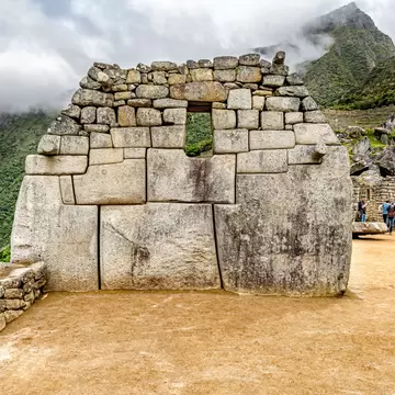 Tourists at Sacred Plaza structures in Machu Picchu, Peru.