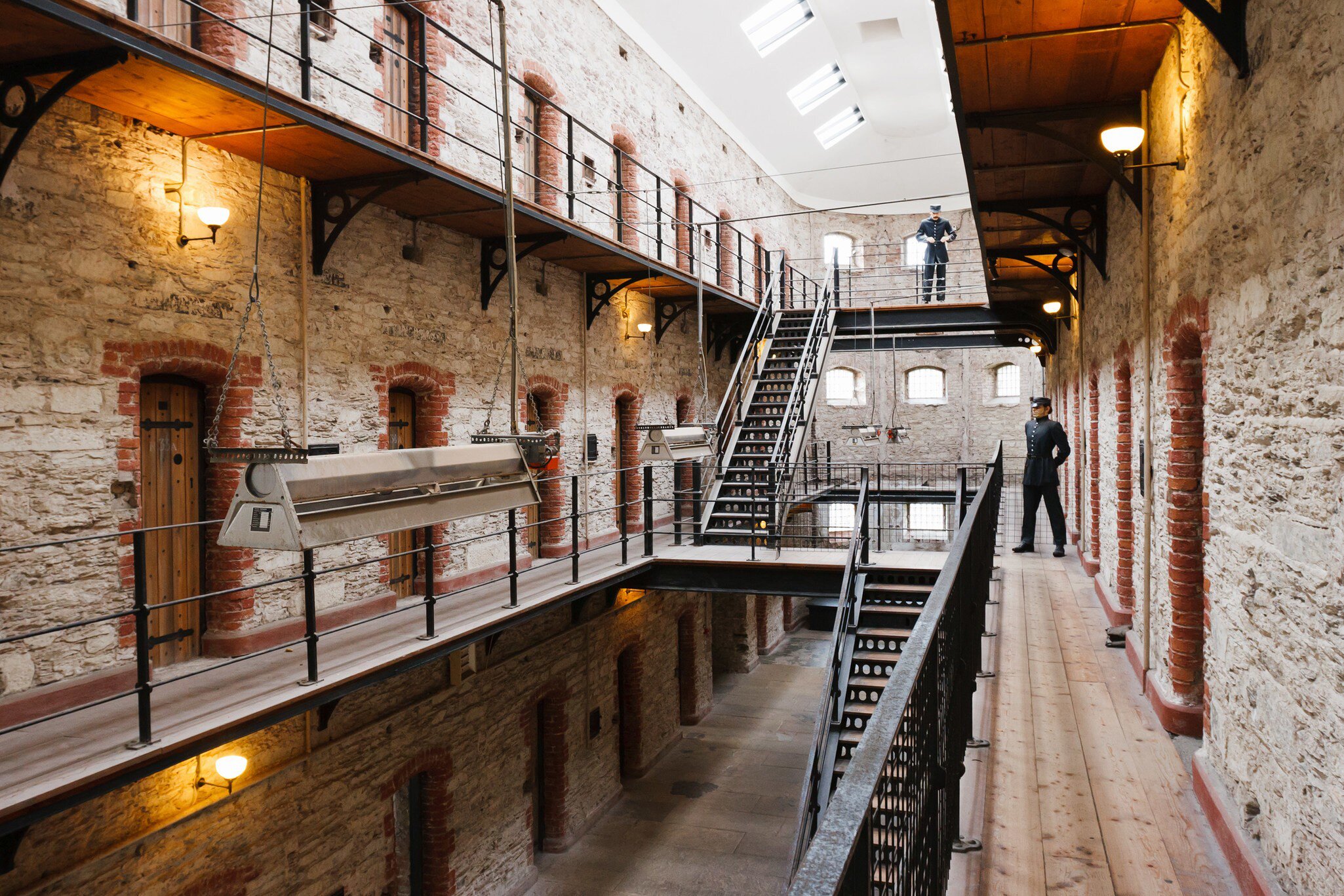 Inside the Cork City Gaol museum in Cork, Ireland.  Prison fixtures and cells with two guards in uniform. 