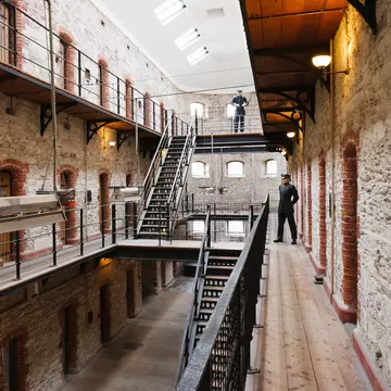 Inside the Cork City Gaol museum in Cork, Ireland.  Prison fixtures and cells with two guards in uniform. 
