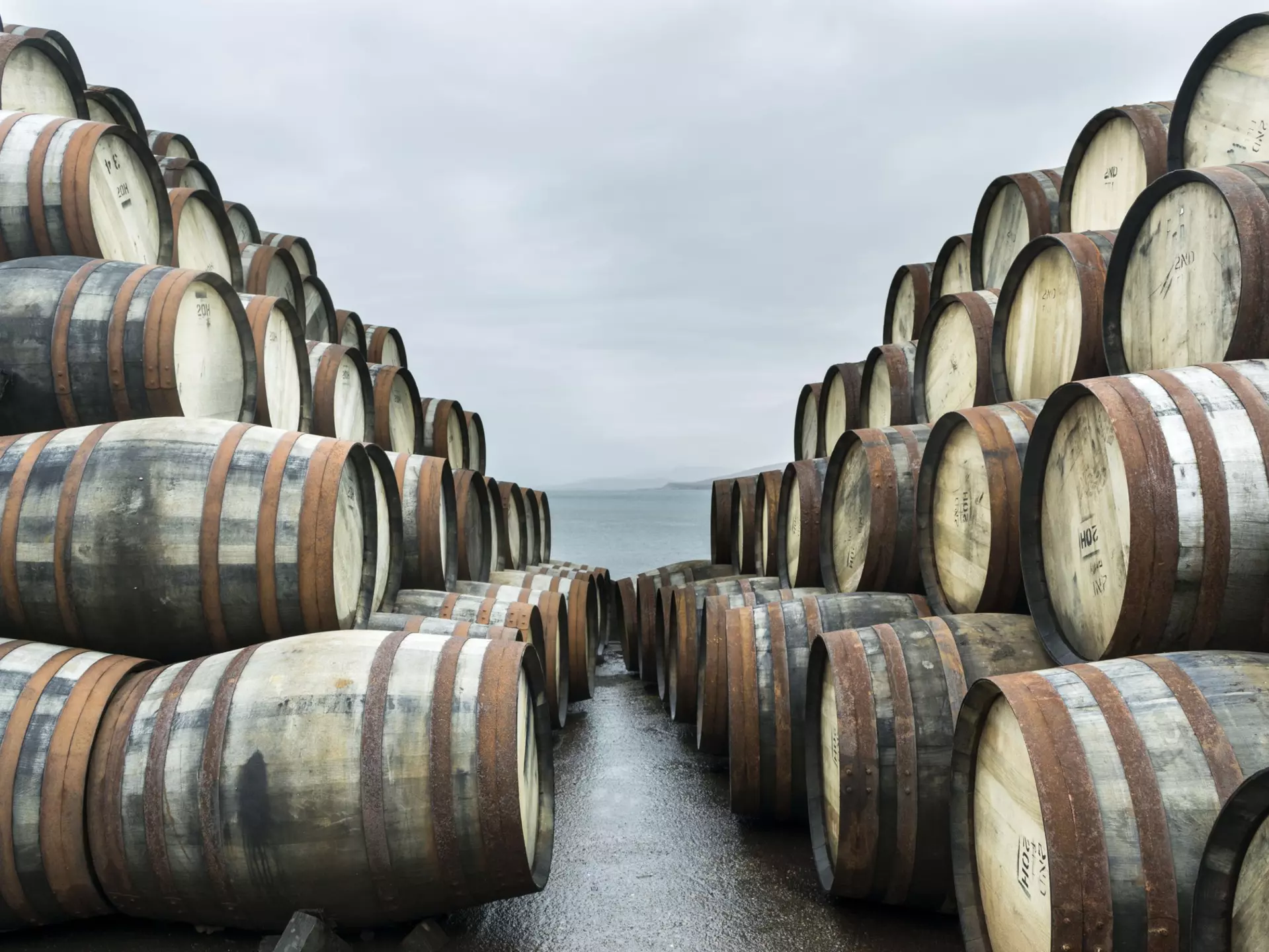 Two large stacks of whisky casks sit outside Bunnahabhain distillery, Isle of Islay, waiting to to be filled with whisky and stored