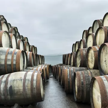 Two large stacks of whisky casks sit outside Bunnahabhain distillery, Isle of Islay, waiting to to be filled with whisky and stored