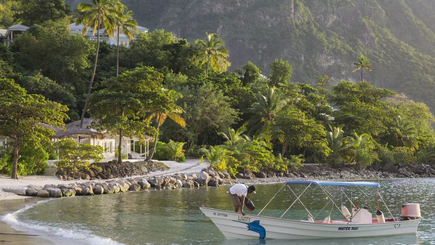 View along Jalousie Beach at sunset, water taxi in foreground, Soufriere, St Lucia