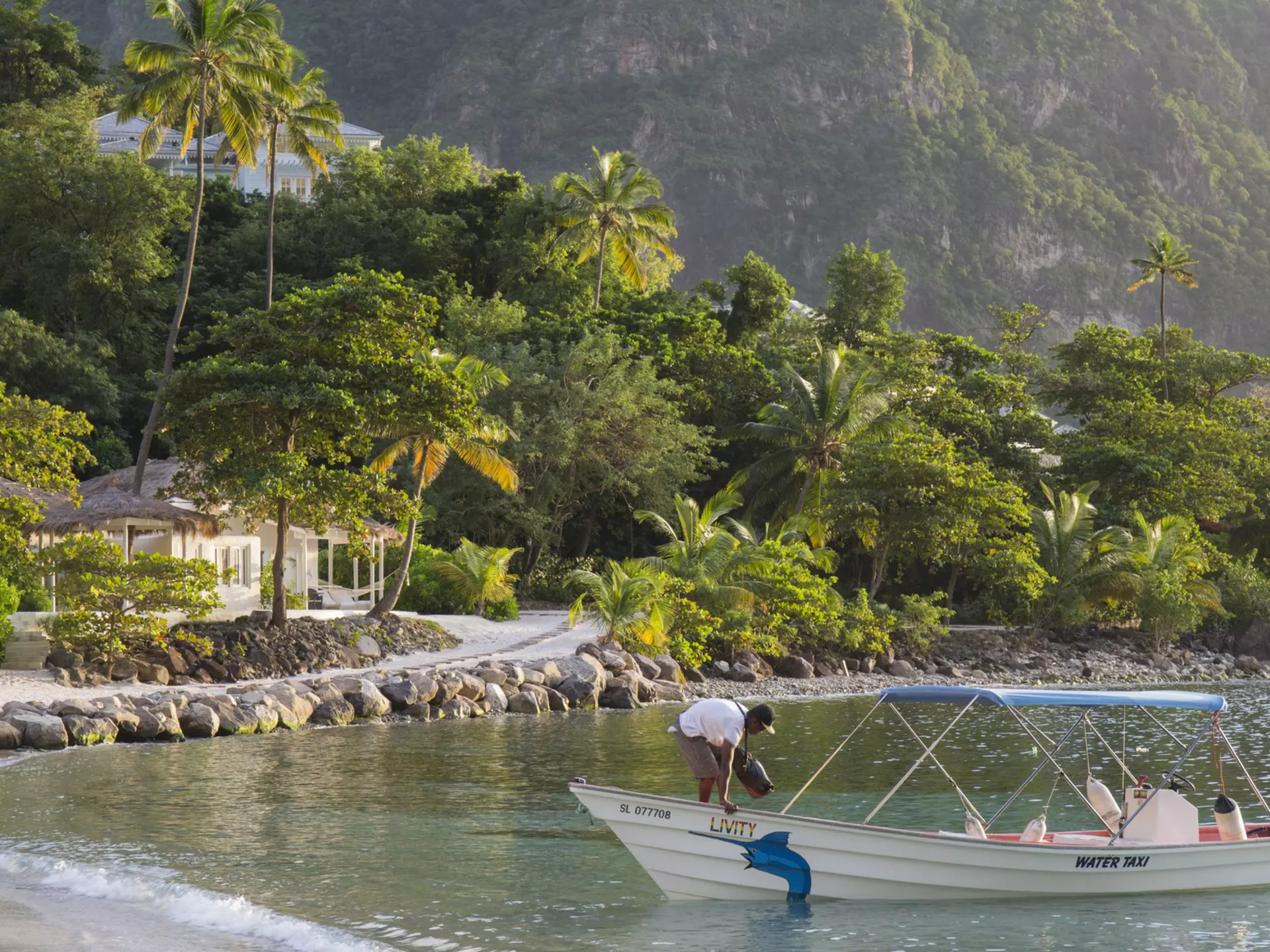 View along Jalousie Beach at sunset, water taxi in foreground, Soufriere, St Lucia