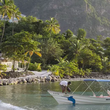 View along Jalousie Beach at sunset, water taxi in foreground, Soufriere, St Lucia