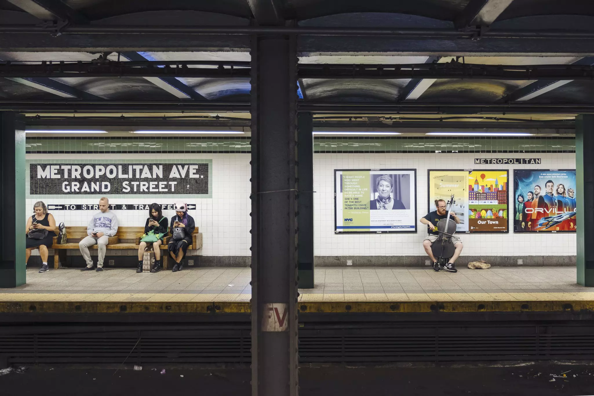 A musician performs on a cello at Metropolitan Ave subway station in Middle Village.