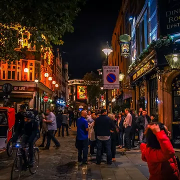 People out at night in the streets of Soho in London, UK.