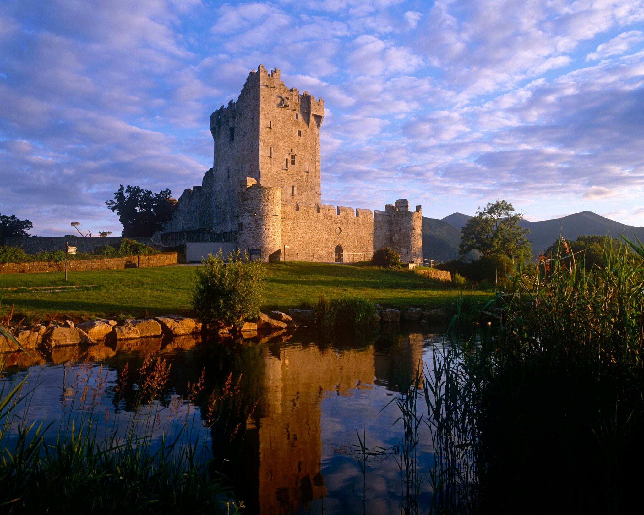 Ross Castle in Killarney next to the river and surrounded by lush green grass