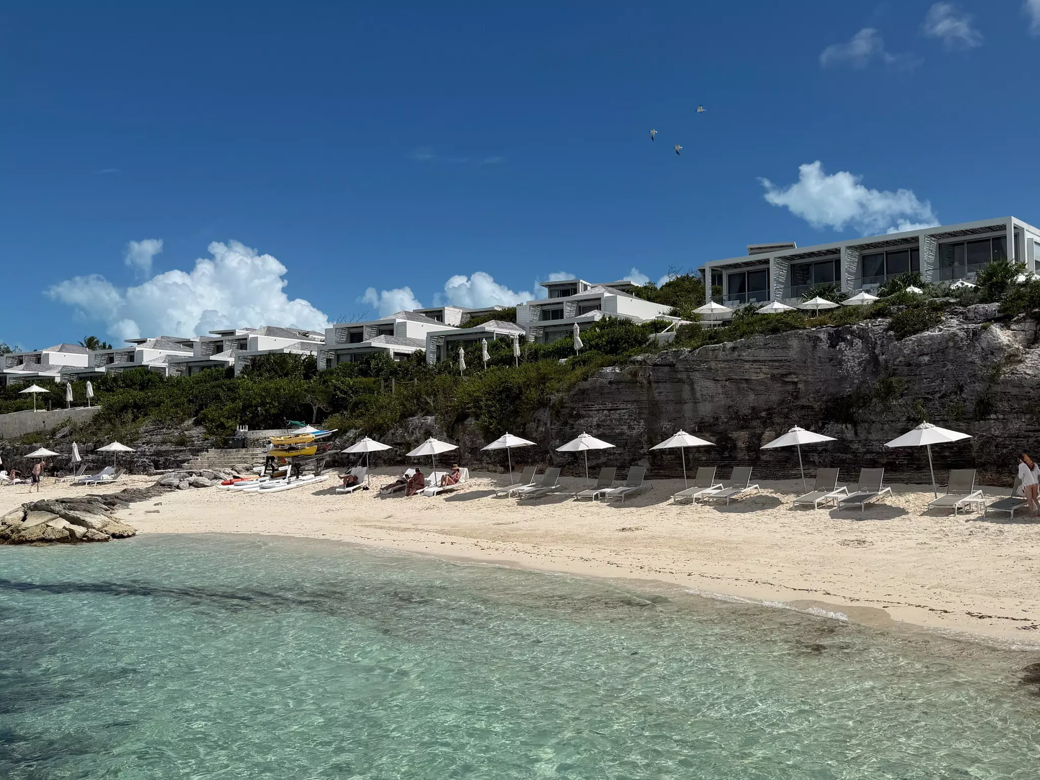 Hotel rooms built on a cliff above a sandy beach