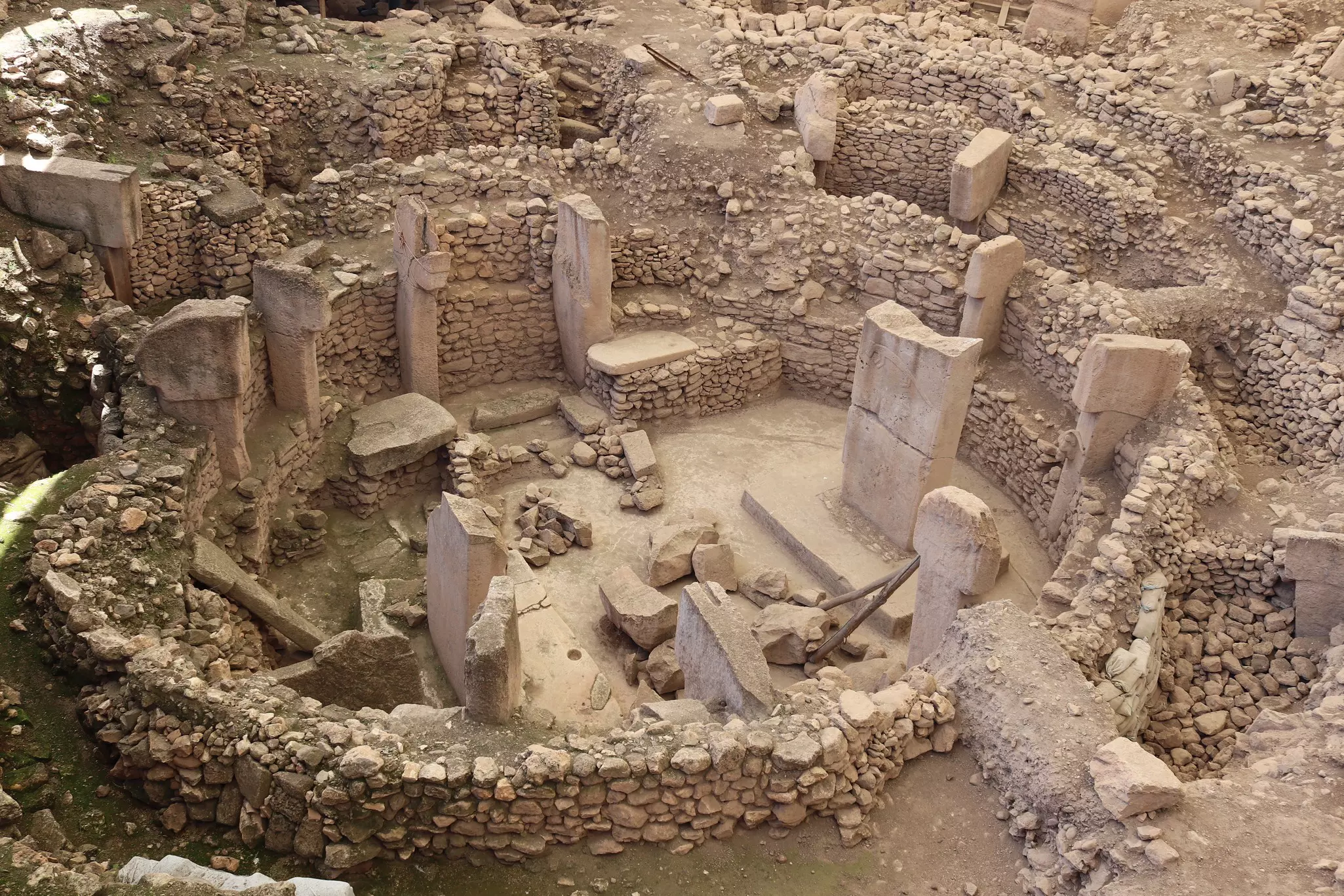 An aerial view of an ancient site in Türkiye with ruins surrounded by rock walls.