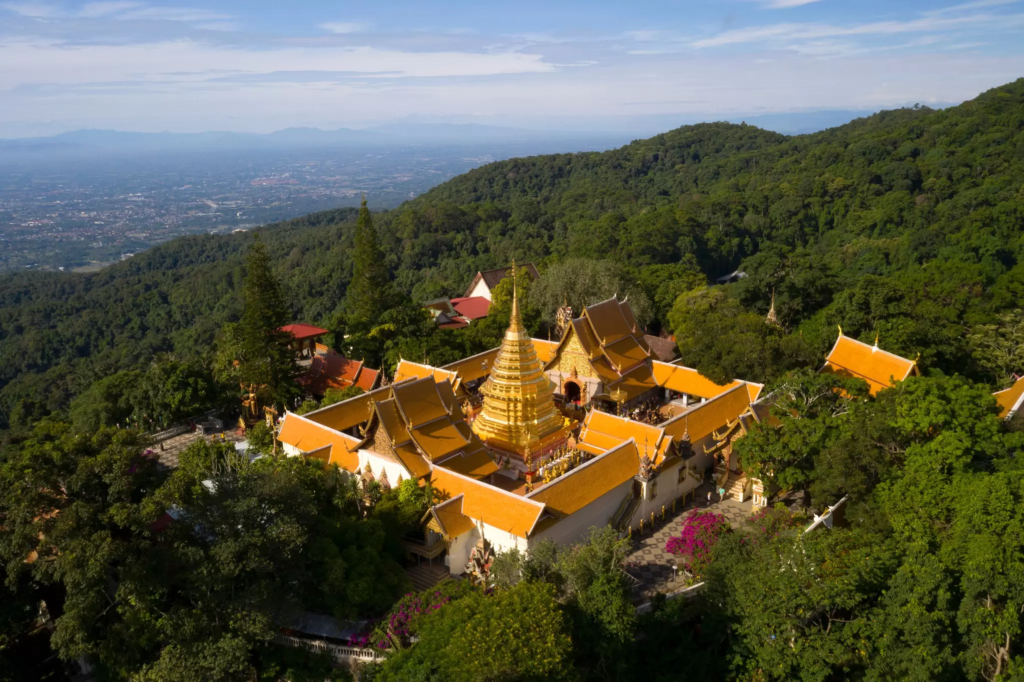 Aerial view of Wat Phra That Doi Suthep temple surrounded by greenery on the mountain in Chiang Mai, Thailand. 