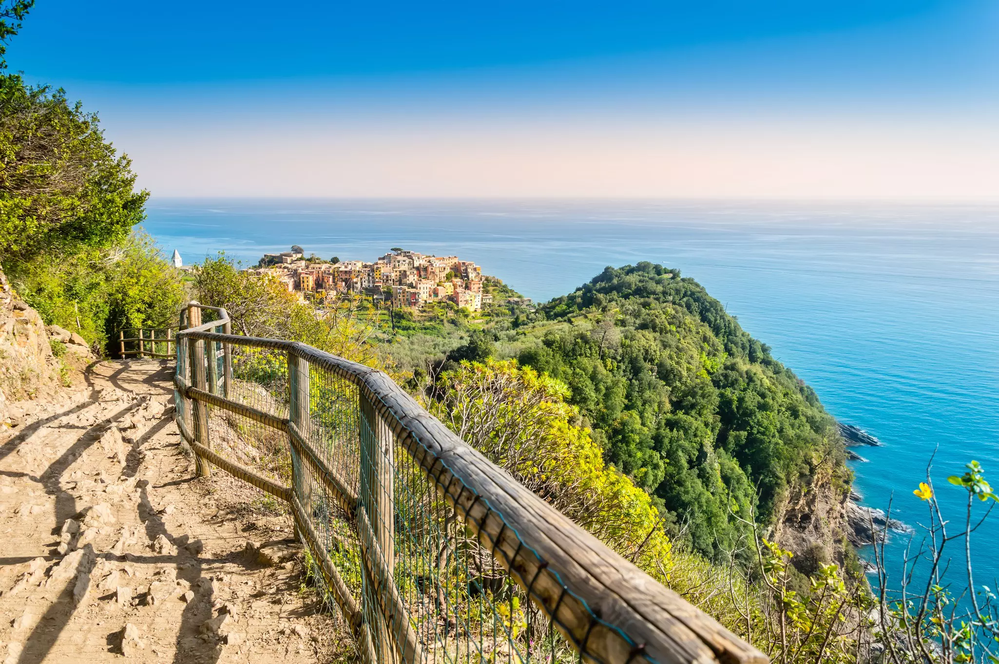 Corniglia, Cinque Terre - hiking trail near beautiful village with colorful buildings on the cliff over sea. Cinque Terre National Park with rugged coastline is famous tourist destination in Italy.