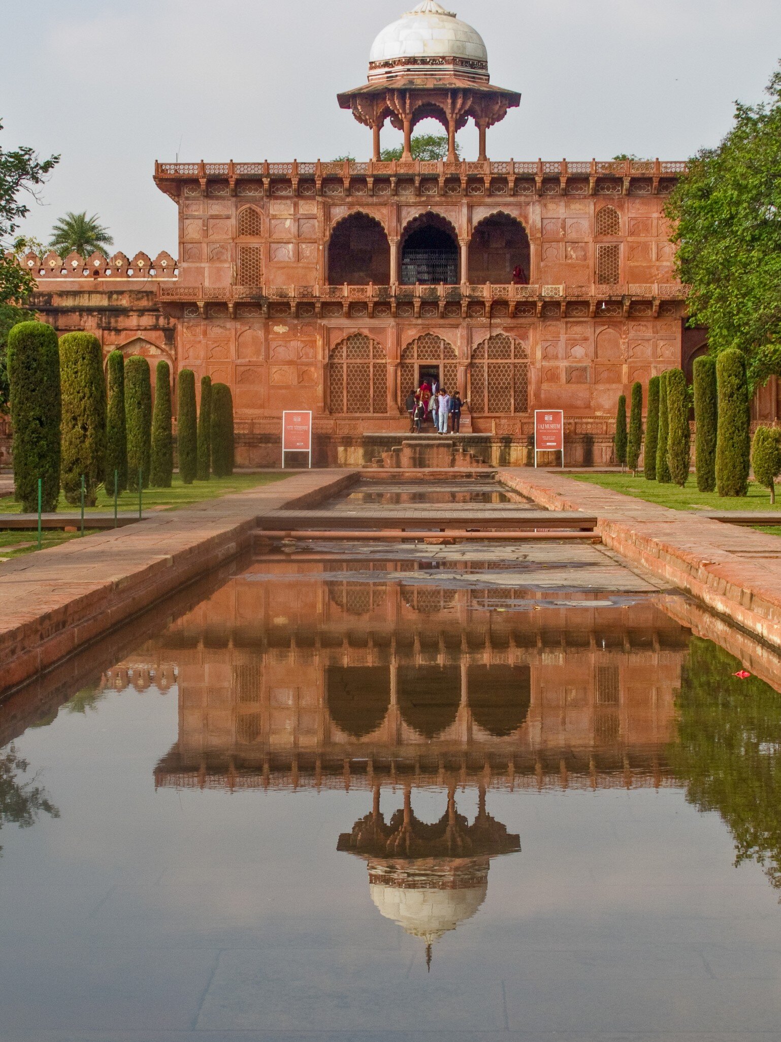 Exterior view of the Taj Museum at the Taj Mahal, Agra, with a reflecting pool in the foreground.