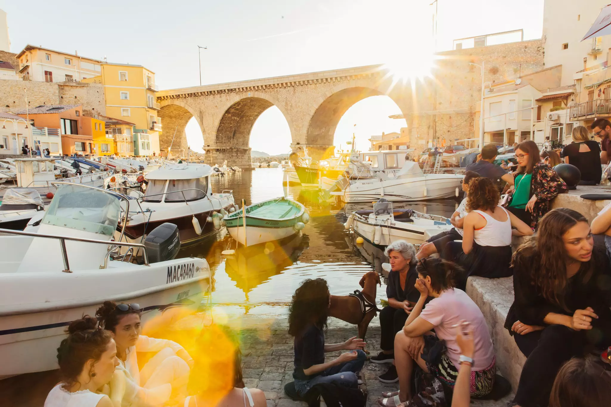 Group of people catching the sunset at Vallon des Auffes, a mini fishing port in Marseille once home to many Italian and Spanish immigrants.