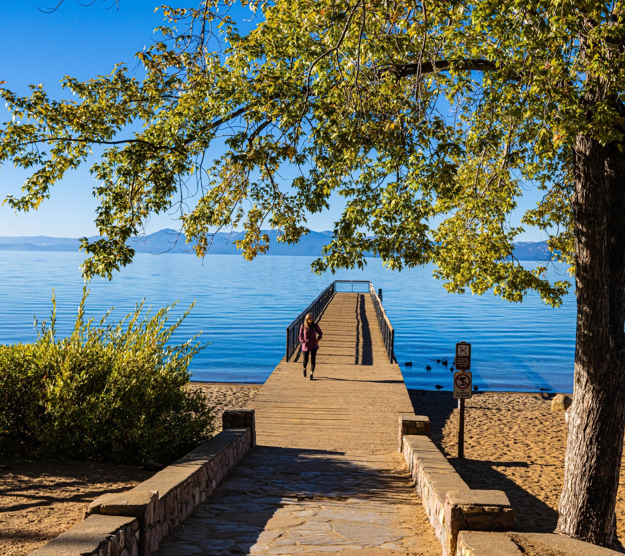 A tourist walks the pier at Kings Beach State Recreation Area, California.
