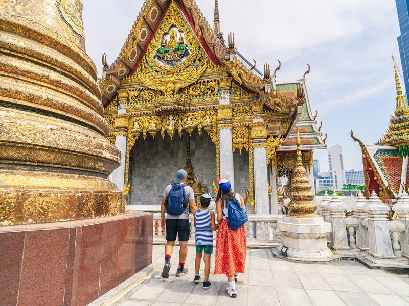 young family with a child visiting the old ornate Wat Hua Lamphong temple in Bangkok, Thailand