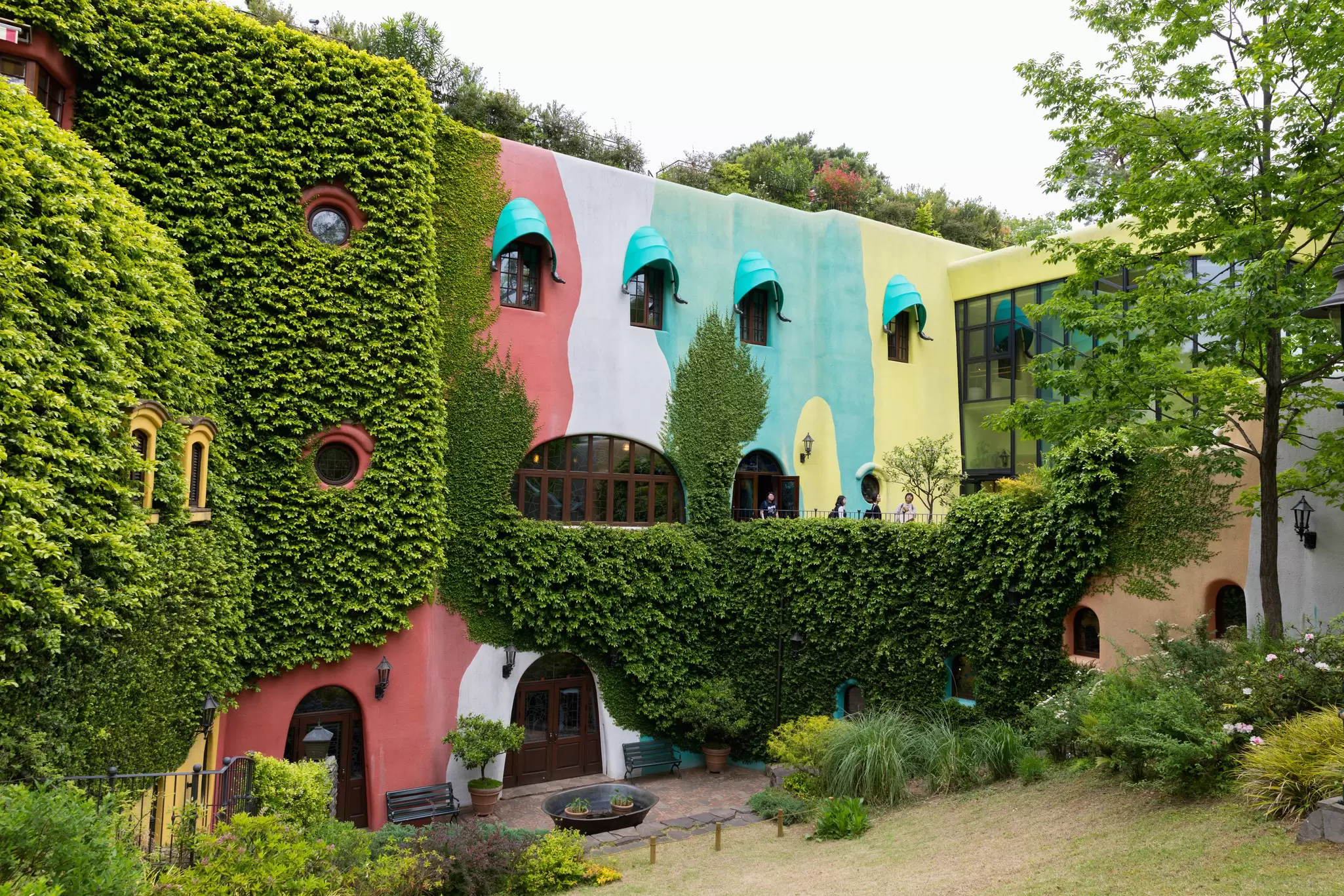 A colorful building surrounded by shrubs. 