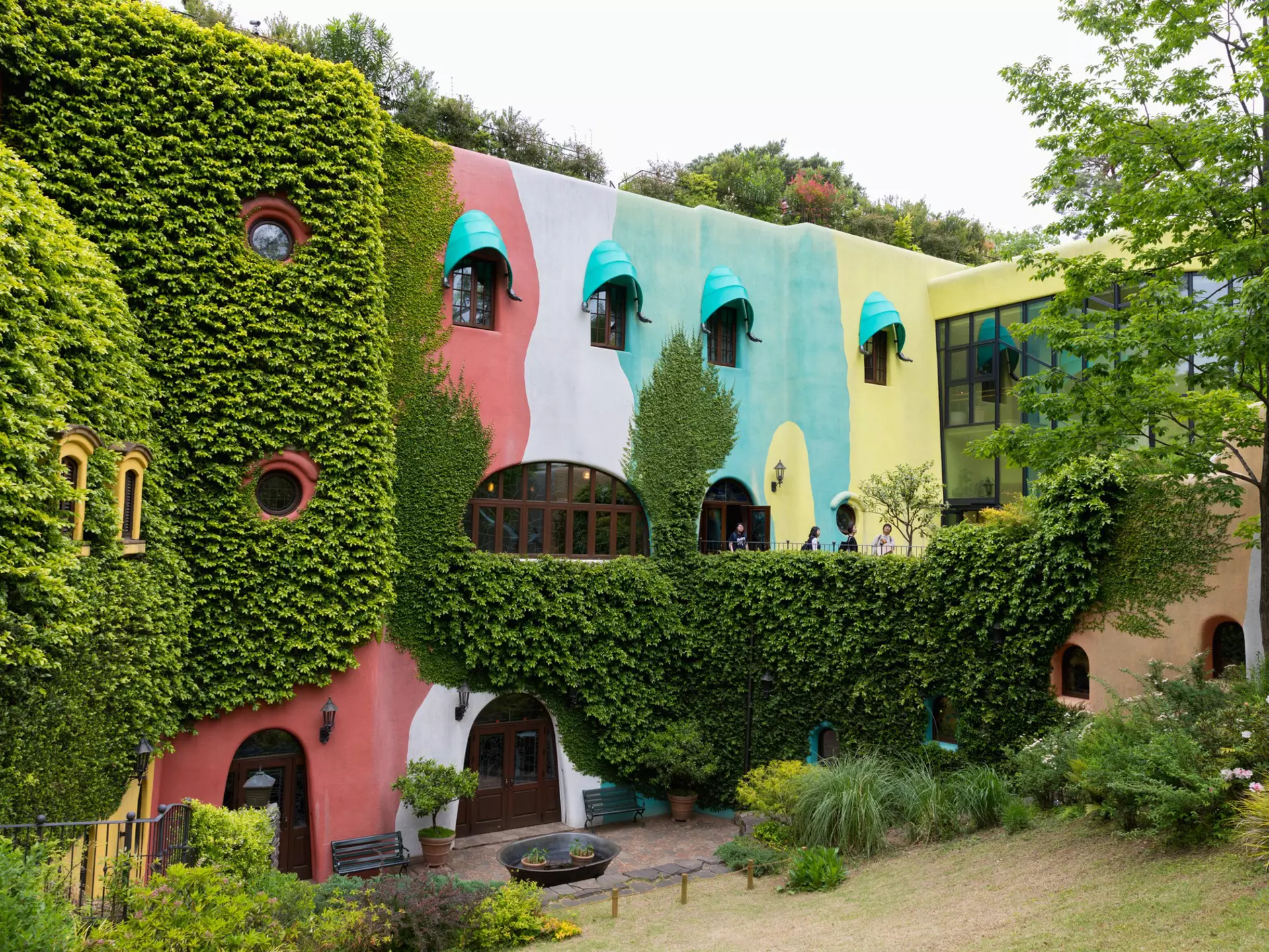 A colorful building surrounded by shrubs. 