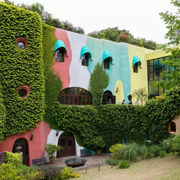 A colorful building surrounded by shrubs. 