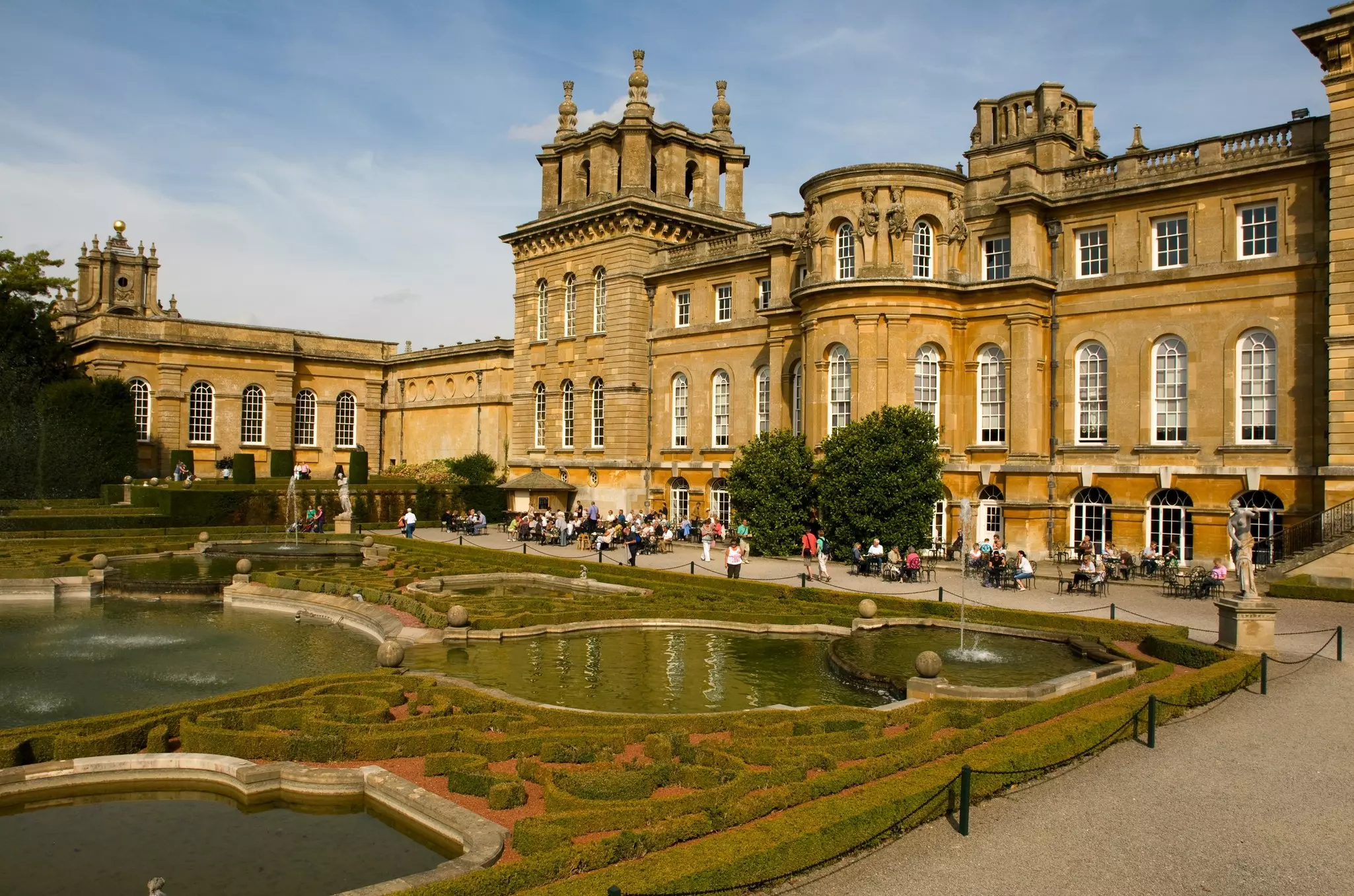 Tourists enjoying the sunshine in the formal gardens at Blenheim Palace, Oxfordshire