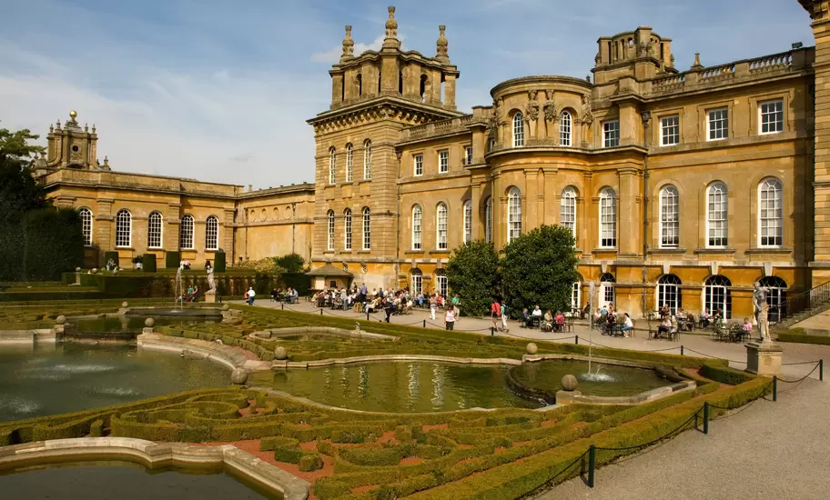 Tourists enjoying the sunshine in the formal gardens at Blenheim Palace, Oxfordshire