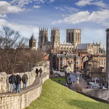 26 January 2015: York, North Yorkshire, England -  a view along the city wall towards York Minster, with tourists walking along the wall.
1127694894
city, people, tourism, yorkshire - england, north yorkshire, england, english culture, minster, cathedral, winter, architecture, history, travel destinations, building exterior, famous place, sky, stone material, travel, fortified wall, gothic style, british culture, british, english, view, medieval, york - yorkshire, surrounding wall, tourist, incidental people