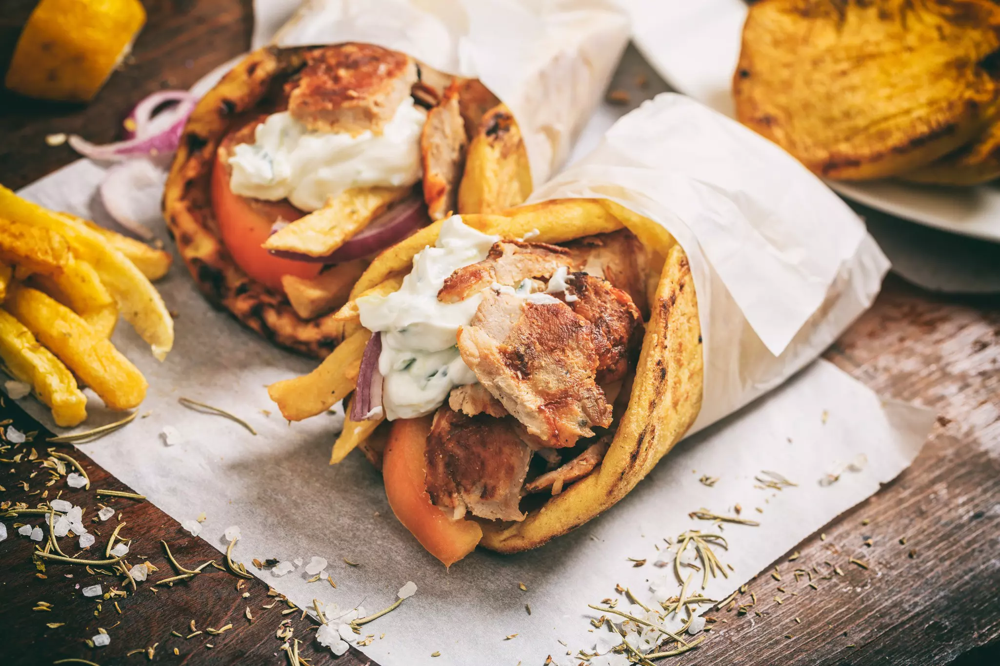 Gyros souvlaki wrapped in a pita bread on a wooden board.