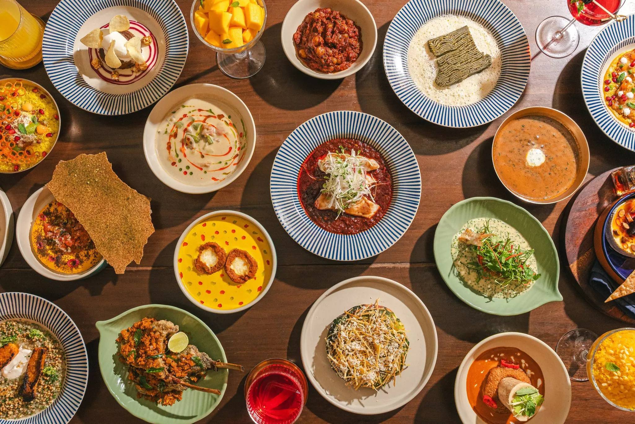 Dozens of beautifully plated dishes are seen from above, displayed on a table