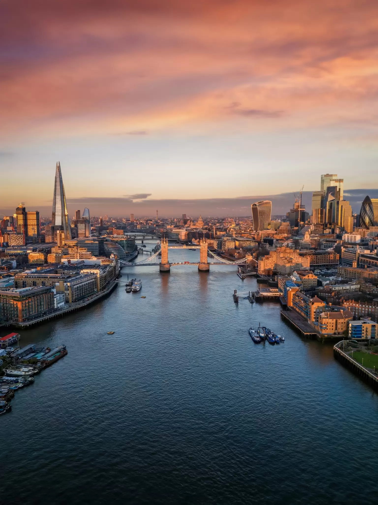 Panoramic view of the skyline of London during a sunrise with Tower Bridge and the skyscrapers of the City in golden, soft light